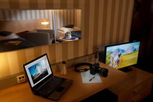 a room with a desk with a laptop and a monitor at Hotel Blue Bratislava in Bratislava