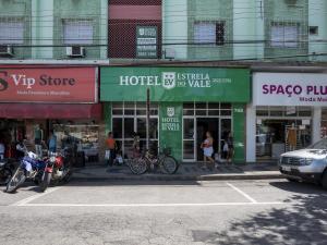 eine Reihe von Geschäften auf einer Stadtstraße mit Motorrädern in der Unterkunft Hotel Estrela Do Vale in Ipatinga