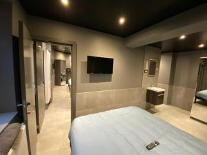a bedroom with a bed and a flat screen tv at Appartement Studio Tournai in Tournai