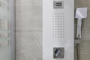 a bathroom with a shower with a clock on the wall at APARTAMENTO PUERTO RICO- HOME RENt MALAGA in Torre del Mar +21 photos