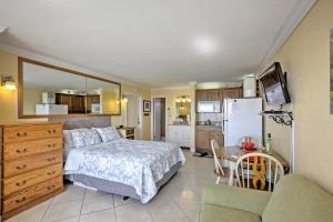 1 dormitorio con cama, mesa y cocina en Daytona Beach Studio with Oceanfront Balcony and Pool!, en Daytona Beach