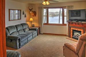 een woonkamer met een bank en een open haard bij Cozy Balsam Lake Home Deck, Private Dock and Kayaks in Balsam Lake