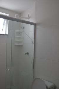 Un baño blanco con ducha y WC. en Le Bon Vivant apto D206, en Arraial do Cabo 19 fotos más
