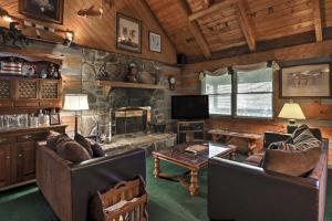 una sala de estar con sofás y una chimenea de piedra. en Gatlinburg Smoky Mountain Cabin about 1 Mi to Park!, en Gatlinburg