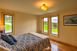 a bedroom with a bed and three windows at Naples Cabin with Lake Views and Wraparound Deck! in Naples