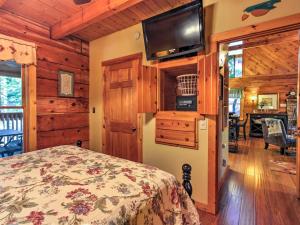 a bedroom with a bed and a flat screen tv at Cozy Nest Gatlinburg Cabin with Porch and Jacuzzi! in Gatlinburg