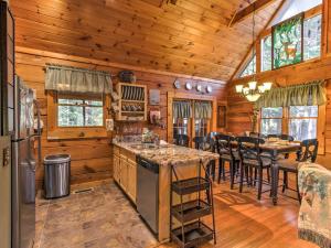 a kitchen and dining room in a log cabin at Cozy Nest Gatlinburg Cabin with Porch and Jacuzzi! in Gatlinburg