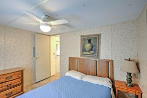 1 dormitorio con 1 cama azul y ventilador de techo en Lakeside Silver Springs Cabin with On-Site Boat Ramp, en Silver Springs