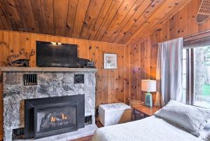 a bedroom with a fireplace with a television and a bed at Lovely Lake Huron Getaway Beach Access and Kayaks! in Evergreen Shores