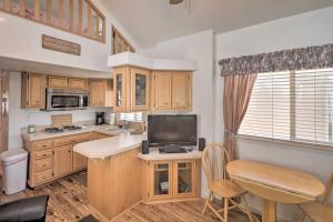 Il comprend une cuisine avec des placards en bois et une télévision à écran plat. dans l'établissement Lake Havasu Cabin with Lake and Mtn Views, Boat Launch, à Lake Havasu City