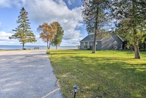 a house on the side of a field with a road at Lovely Lake Huron Getaway Beach Access and Kayaks! in Evergreen Shores