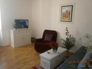 a living room with a chair and a tv at Haus Felix in Labin