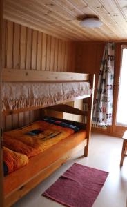 ein Etagenbett aus Holz in einem Zimmer mit einem Teppich in der Unterkunft Bühlerhof in Lenk im Simmental