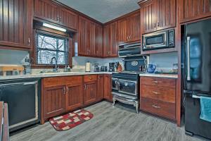 uma cozinha com armários de madeira e um forno com placa de fogão em Lawrence Area Vacation Rental 15 Mi to Topeka! em Lecompton