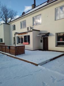 a house with snow on the ground in front of it at Raasiku Hotell in Raasiku