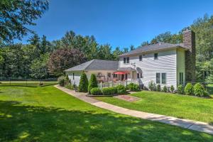 a white house with a fence and a yard at Serene Orchard Park Apartment Large Yard and Patio! in Orchard Park