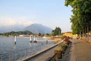 a sidewalk next to a body of water with a mountain at CASA DELLA VALLE in Colico