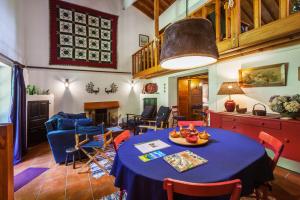 een woonkamer met een tafel met een blauwe tafeldoek bij Casa da Cascata in Furnas