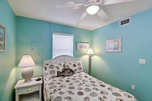 una camera con letto e ventilatore a soffitto di Beachfront Cedar Key Condo with Pool, Spa and Views! a Cedar Key