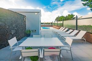 een rij tafels en stoelen op een patio bij Villa Dreams in Playa Blanca