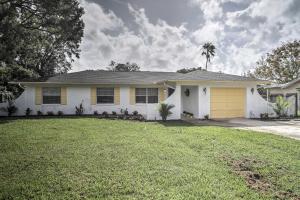 a white house with a yellow garage at Quiet Home Near Shopping and 15 Miles From Orlando! in Orlando