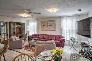 ein Wohnzimmer mit einem lila Sofa und einem TV in der Unterkunft Quiet Home Near Shopping and 15 Miles From Orlando! in Orlando