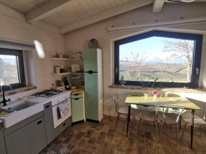 a kitchen with a table and a large window at Il Melograno House in Pollutri