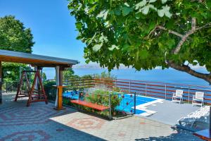 a picnic shelter with a bench and a tree at Vacation home TEA in Senj