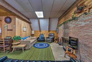een woonkamer met een bank en een bakstenen muur bij Forest Views and Porch Family Cabin in Ruidoso in Ruidoso