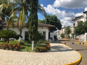 eine Straße mit Palmen und Blumen vor einem Gebäude in der Unterkunft Enseada Nautico Residence in Caldas Novas