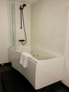 a white bath tub in a bathroom with a shower at New, modern apartment near the centre of Tórshavn in Tórshavn