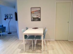 una mesa y sillas blancas con una foto en la pared en New, modern apartment near the centre of Tórshavn, en Tórshavn