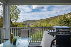 un patio con parrilla, mesa y sillas en Les Manoirs by Rendez-Vous Mont-Tremblant, en Mont-Tremblant