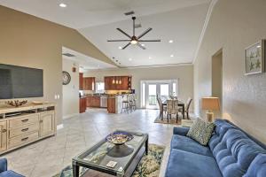 a living room with a blue couch and a tv at Oceanfront Oasis with Deck, Water Views and Beach Gear in Flagler Beach