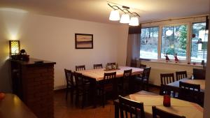 a dining room with a wooden table and chairs at NIEZAPOMINAJKA in Szczyrk