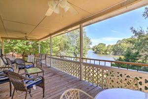 a deck with chairs and tables and a view of a river at Lakefront Cottage with Private Hot Tub! in Buckhead
