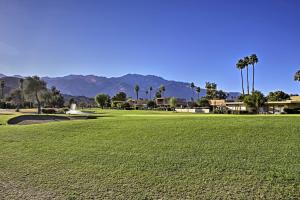 un campo verde con palmeras y montañas al fondo en Palm Springs Townhome with Pool and Golf Access!, en Palm Springs