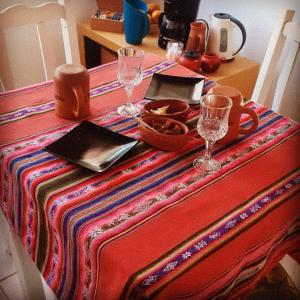 a table with two wine glasses on top of it at Hostal Tierra Andina Cafayate in Cafayate