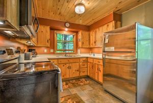 una cucina con armadi in legno e frigorifero in acciaio inossidabile di Trout Lake Cabin with Private Dock, Kayaks and Loft! a Grand Rapids