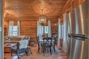 un soggiorno con un tavolo e un frigorifero di Ruidoso Log Cabin Retreat - Peaceful and Convenient a Ruidoso
