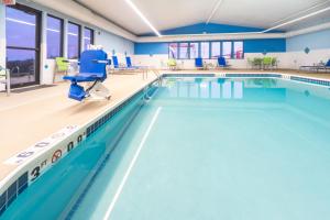 a swimming pool with a blue floor and blue chairs at Holiday Inn Express Rochelle, an IHG Hotel in Rochelle
