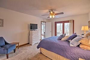 1 dormitorio con 1 cama y ventilador de techo en Lake Lanier Home with Dock, Boat Parking, and Grill!, en Gainesville