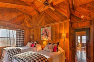 Un dormitorio con dos camas en una habitación con paredes de madera. en Cozy Cumberland Mountain Cabin with Stunning Views!, en Beersheba Springs