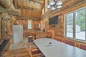 a kitchen and dining room in a log cabin at Custom Log Cabin with Deck and 45 Acres By Pine River! in Tustin