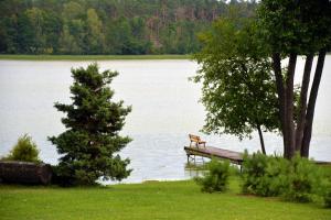 a bench sitting on a dock on a lake at Latkrantė in Latežeris