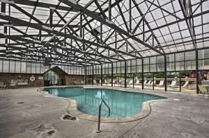 a large swimming pool in a building with a glass ceiling at Sevierville Cabin with Hot Tub, Views and Pool Access! in Sevierville