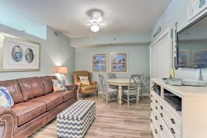 a living room with a couch and a table at Beachfront Gulf Shores Condo with Patio, Pool Access in Gulf Shores
