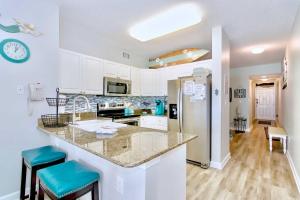 a kitchen with white cabinets and a counter top at Beachfront Gulf Shores Condo with Patio, Pool Access in Gulf Shores