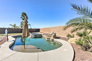 einen Pool mit Sonnenschirm und Pool in der Unterkunft Maricopa House with Private Pool and Putting Green! in Maricopa