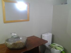 a bathroom with a bowl on a table next to a toilet at Fare Manutea in Nuku Hiva